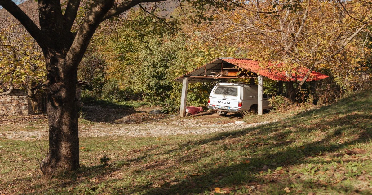 Petit abri à toit incliné protégeant un véhicule à la campagne
